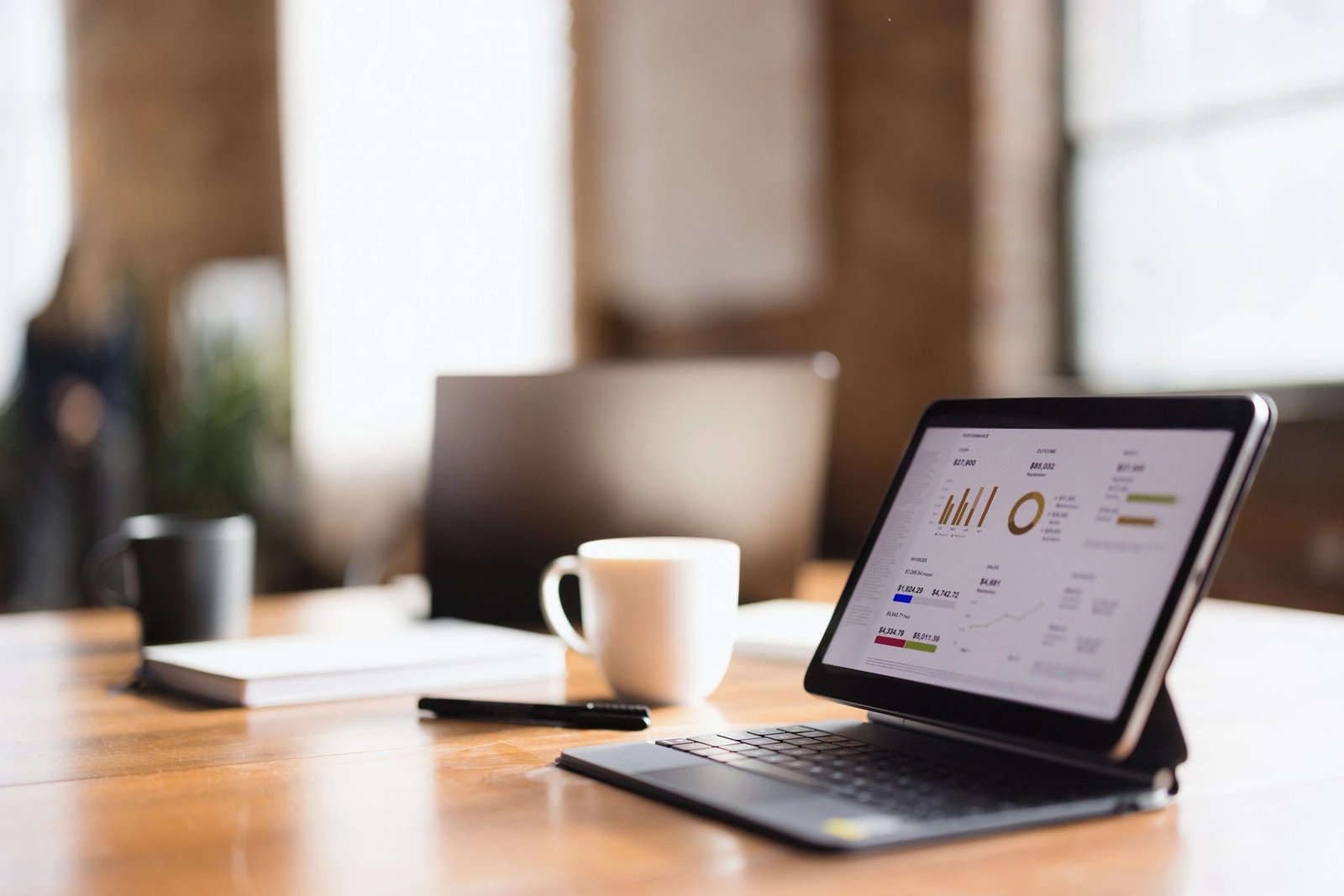 Tablet and laptop on a professional office desk showing business data